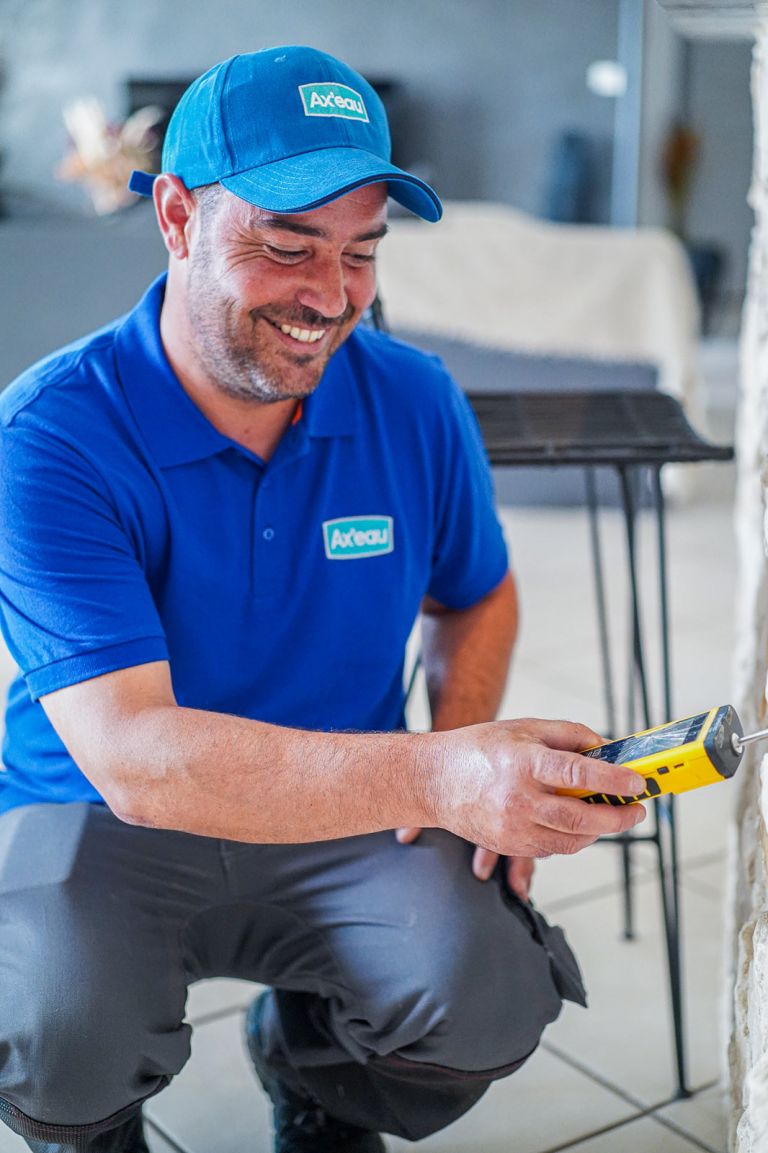 Technicien recherche de fuite effectuant une mesure d'humidité