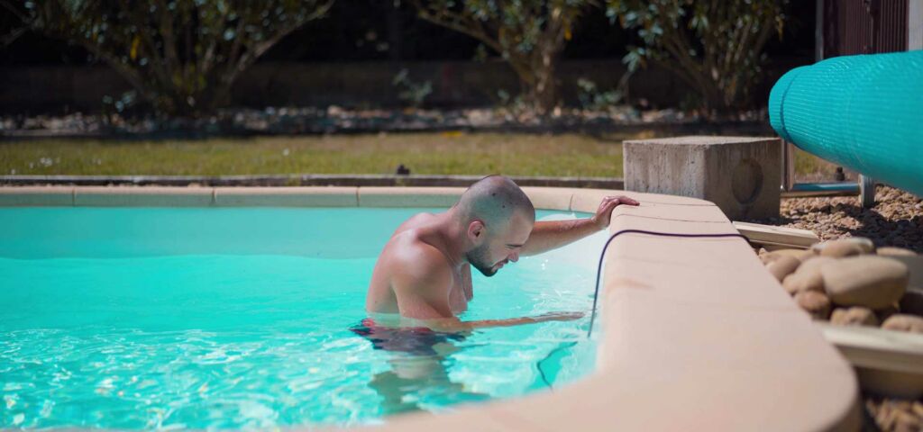 technicien recherchant une fuite au niveau de la bonde de fond de la piscine